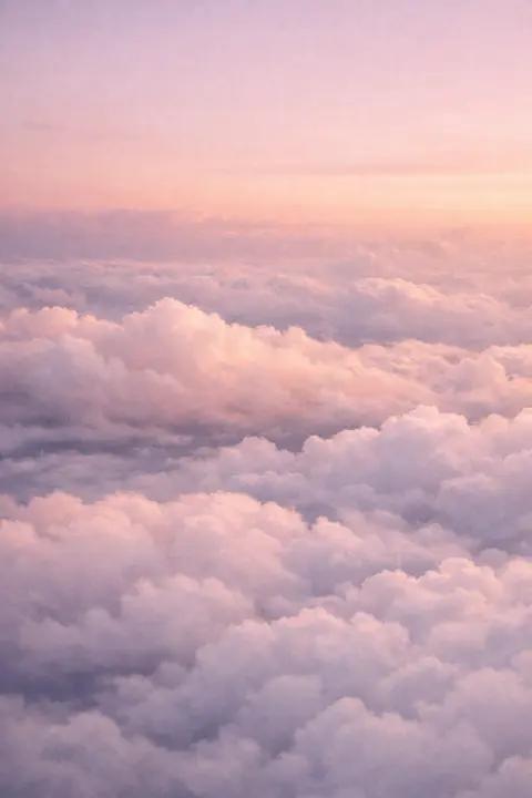 Aesthetic cloud wallpaper with stacked layers of soft cloud seen from above in muted peach