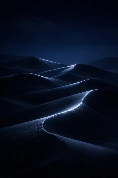 Midnight wallpaper with smooth desert dunes under a deep blue sky and moonlight on each crest