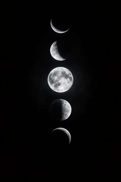 Dark minimalist wallpaper of silver moon phases on true black