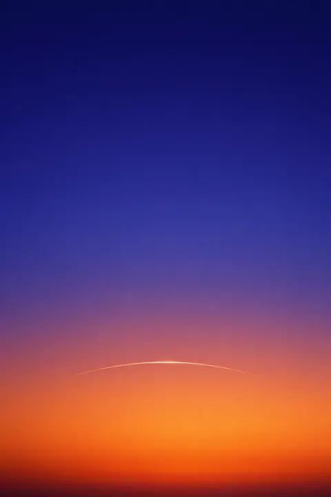 Minimalist sunset wallpaper with a smooth indigo to orange gradient and one thin sun arc
