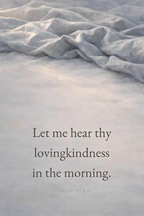 Bible verse wallpaper with Psalm 143:8 in serif type over pale dawn light falling on grey linen